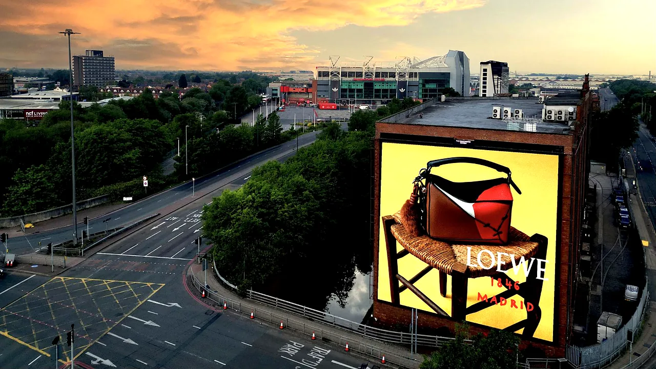 The Manchester Screen showing a Loewe campaign at sunset, with Old Trafford behind